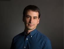 Man with brown hair and navy button down.