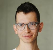 Man with brown hair and glasses.