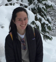 Brown haired woman smiling in front of a snowy background