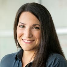 Woman with black hair and gray blouse smiling