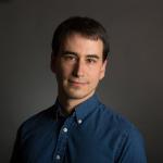 Man with brown hair and navy button down.